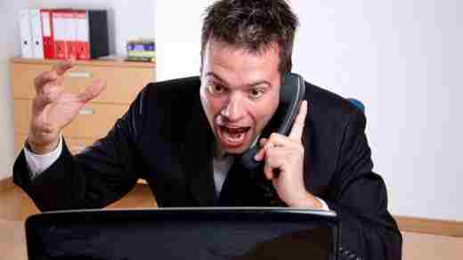 Man Angry at Computer on Phone in Office